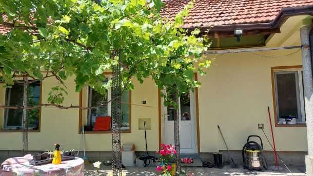 De voordeur van het huis is aan de kant van de tuin, tegenover de straatzijde.